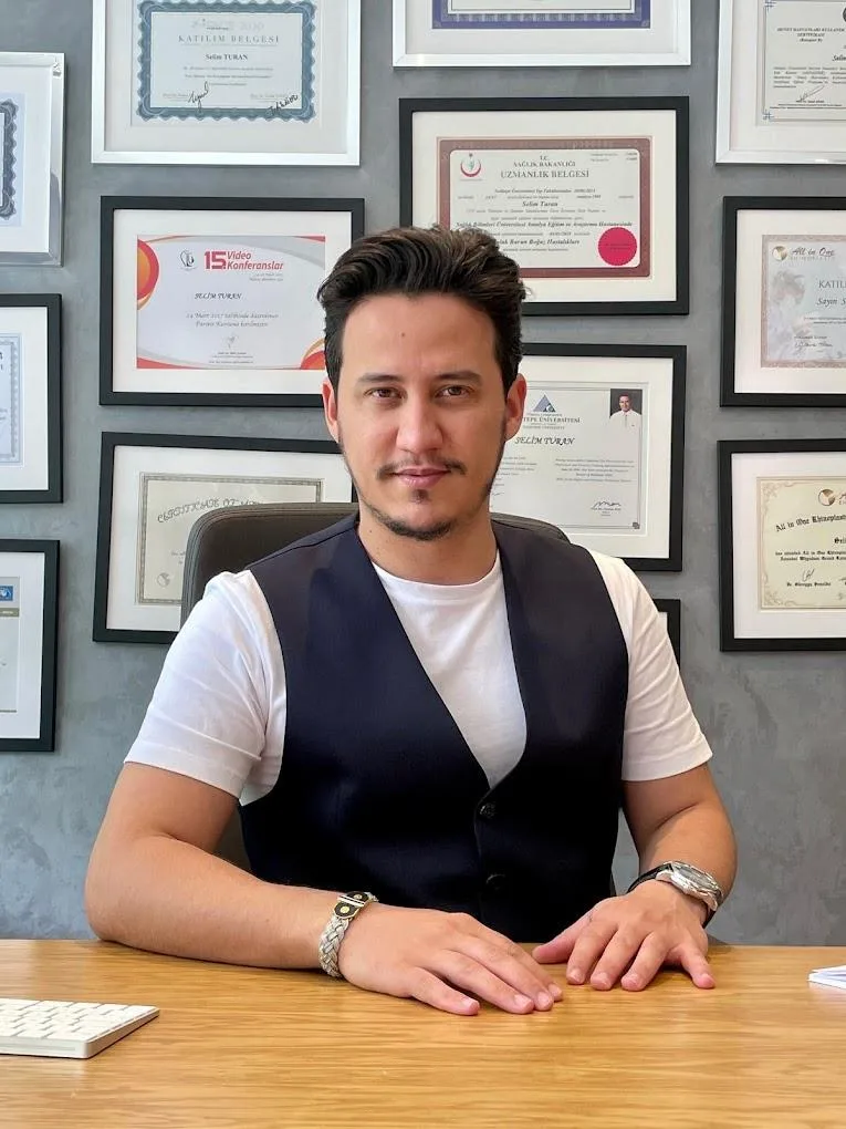 Dr. Selim Turan in his office with certificates on the wall